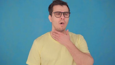Middle-aged man in glasses and t-shirt problems with sore throat,uses spray to Stock Footage 107109161