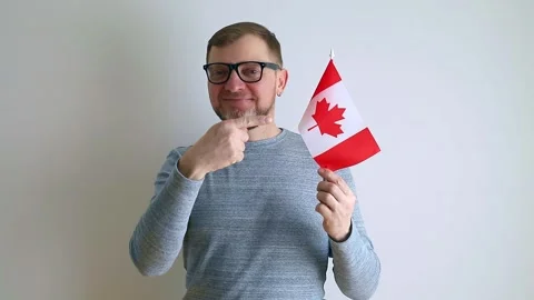 Middle aged man with glasses waving the flag of Canada. Stock Footage 240108507