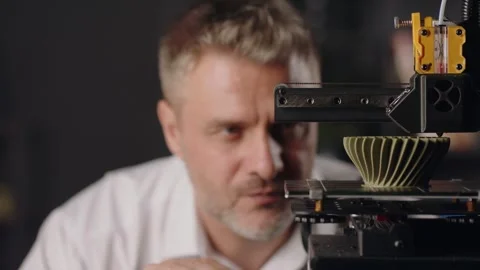 A middle aged man graphic designer observes the working process of 3d printer Video stock 260068484