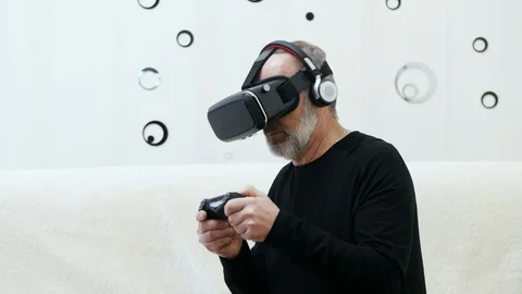 Middle-aged man with grey beard play in virtual reality video game with wireless Stock Footage 124618904