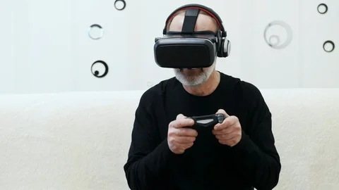 Middle-aged man with grey beard play in virtual reality video game with wireless Stock Footage 124618944