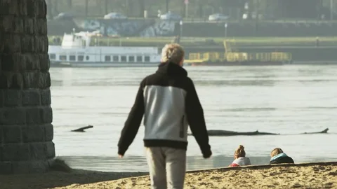 Middle-Aged Man in Grey Clothes Walking Along the River Stock Footage 80286508