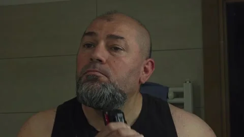 Middle-Aged Man Grooming and Shaving His Beard in the Mirror Stock Footage 337164602