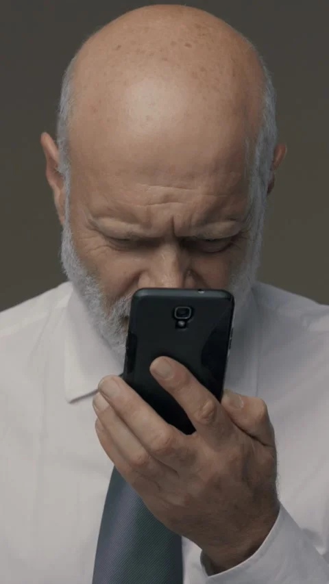 Middle-aged man having difficulties and vision problems using his smartphone 動画素材 293680288