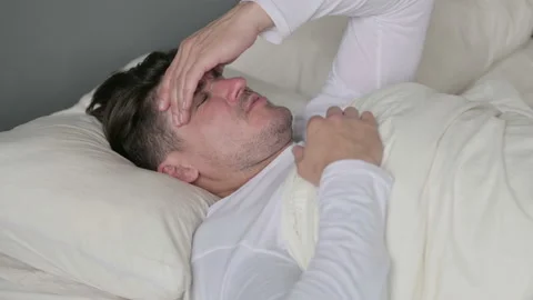 Middle Aged Man with Headache Sitting in Bed 스톡 동영상 142377314