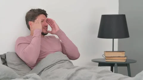 Middle Aged Man with Headache Sitting in Bed Video stock 287403554