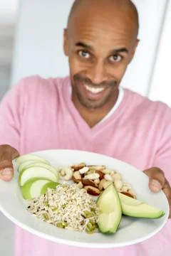 Middle Aged Man Holding Out A Plate With Healthy Foods Stock Photos