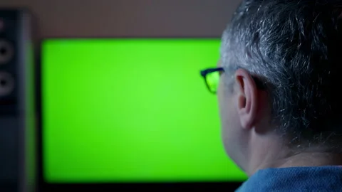 Middle-aged man holding a remote control as he watches TV Stock Footage 167168142