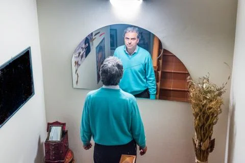 Middle-aged man at home in front of mirror Stock Photos
