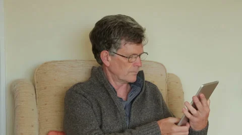 Middle aged man at home using tablet computer Stock Footage 33211276