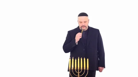 Middle aged man ignites the Menorah white screen Stock Footage 105002082