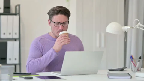 Middle Aged Man with Laptop Drinking Coffee having Toothache Stock Footage 143567055