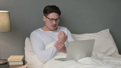 Middle Aged Man with Laptop having Wrist Pain in Bed 스톡 동영상 142369889