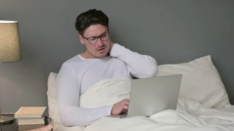 Middle Aged Man with Laptop having Neck Pain in Bed Video stock 142370930