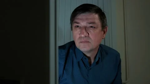 Middle-aged man, late at night looking at a computer monitor Stock Footage 149075655