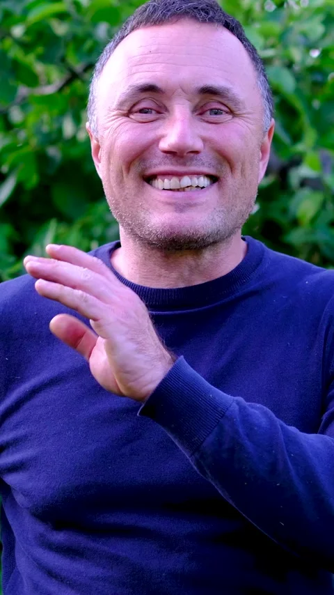 Middle aged man laughing sincerely and clapping hands with joy while enjoying Stock Footage 345744359