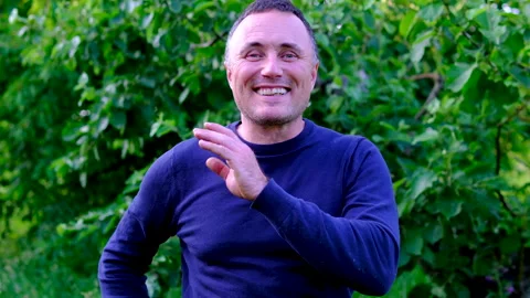 Middle aged man laughing sincerely and clapping hands with joy while enjoying Stock Footage 345746554
