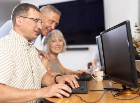Middle-aged man learning computer programs in training room Fotos de archivo