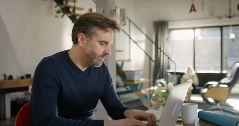Middle aged Man looking worried at his Laptop at Home Stock Footage 86555446