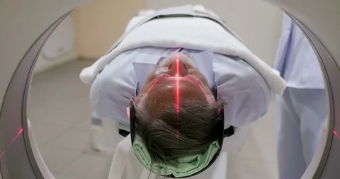 Middle aged man lying on the CT scanner during machine imaging his body. Stock Footage 90832674