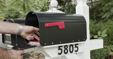 Middle aged man mails international letter from small town residential mail box Stock Footage 137920515