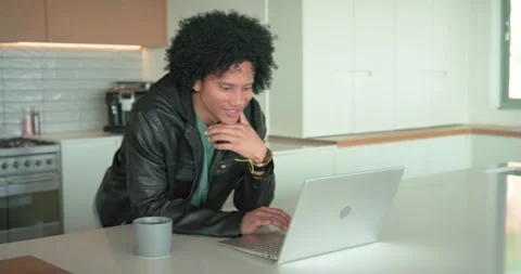 Middle-aged man noticing message on laptop at kitchen island, leaning, typing Stock Footage 340257003
