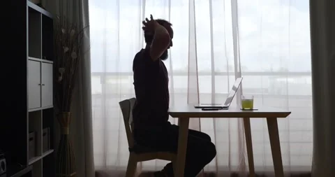 Middle-aged man pausing while working from his living room on his laptop Stock Footage 160680301