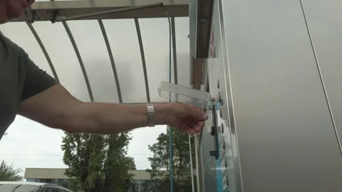 Middle-aged man pays for a self-service car wash Stockbeeldmateriaal 201171756