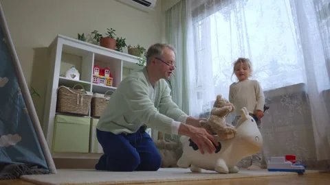 A middle-aged man is playing with his toddler in the living room Stock Footage 307193487