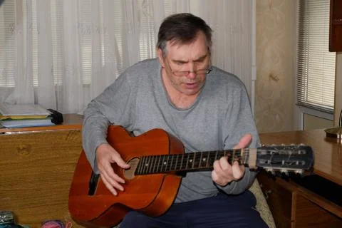 Middle-aged man playing old guitar visible human hands instrument house Stock Photos