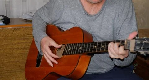 Middle-aged man playing old guitar visible human hands instrument house Stock Photos