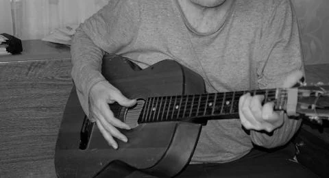 Middle-aged man playing old guitar visible human hands instrument house apa.. Stock Photos