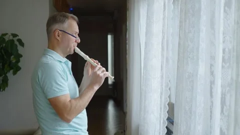 A middle-aged man playing recorder flute. Stock Footage 303782085