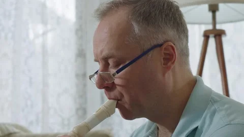 A middle-aged man playing recorder flute. Stock Footage 303782247