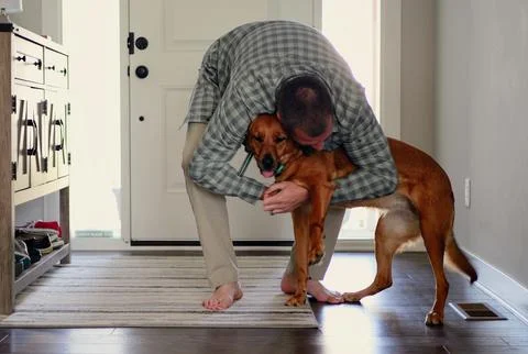 Middle Aged Man Playing with Rescue Dog Indoors 스톡 사진