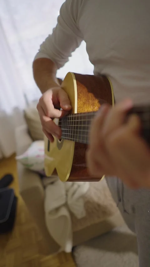 A middle-aged man plays his acoustic guitar alone Stock Footage 303781549