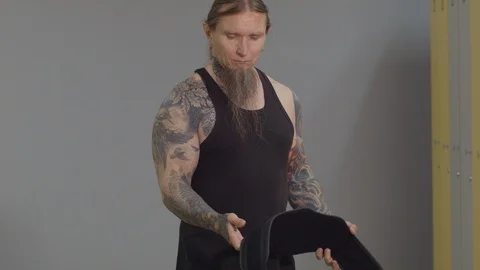 A middle-aged man puts on a training belt for exercise Stock Footage 115428904