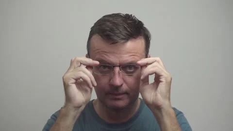 Middle-aged man is putting on glasses. Life in glasses Stock Footage 318525420