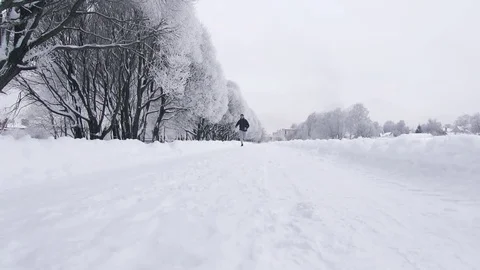 Middle-aged man quietly running around the winter park Video stock 85032244