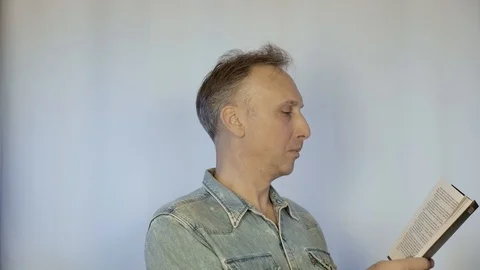 A middle aged man is reading a book. Video stock 98173808