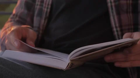 Middle aged man reading book on sunset, freelancer on balcony read during home Stock Footage 143648321