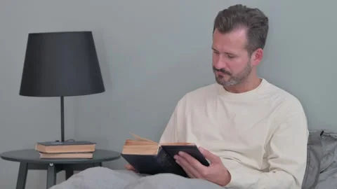 Middle Aged Man Reading Book in Bed 스톡 동영상 287899172