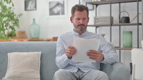 Middle Aged Man Reading Documents at Home Stock Footage 287897686