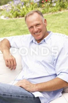 Middle Aged Man Relaxing In Garden Stock-Fotos