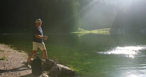 A middle-aged man rests on a weekend on a mountain lake Stock Footage 246491809