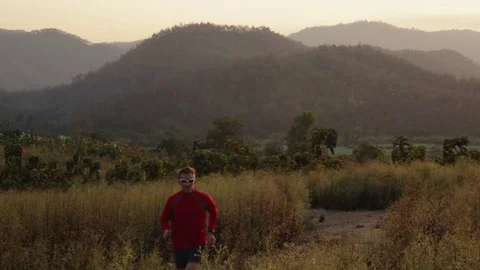 Middle aged man running in mountains of Thailand at sunset Stock Footage 79082035
