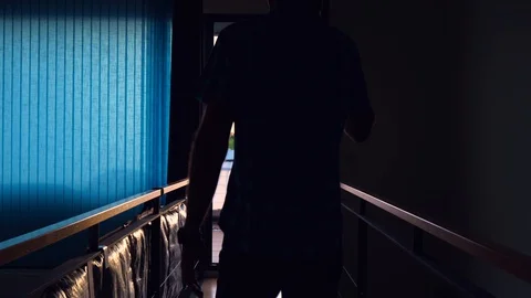Middle-aged man in shorts talking on his cell phone at home Stock Footage 127588573