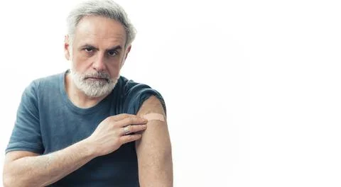 Middle-aged man showing the arm patch after the vaccination - immunization 스톡 사진