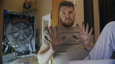 Middle-aged man shows dirty hands after repairing washing machine Stock-Footage 155643795