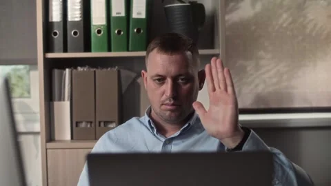Middle-aged man sits at a desk in an office and communicates Stock Footage 307597967